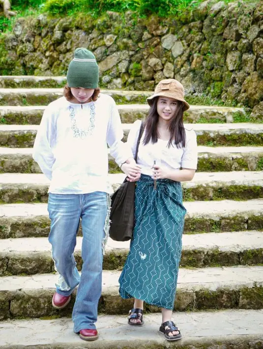 Tissa Biani tampil dengan atasan putih lengan 3/4 yang dipadukan kain lilit bercorak warna hijau sebagai bawahan dan sandal hitamnya. [@tissabiani]