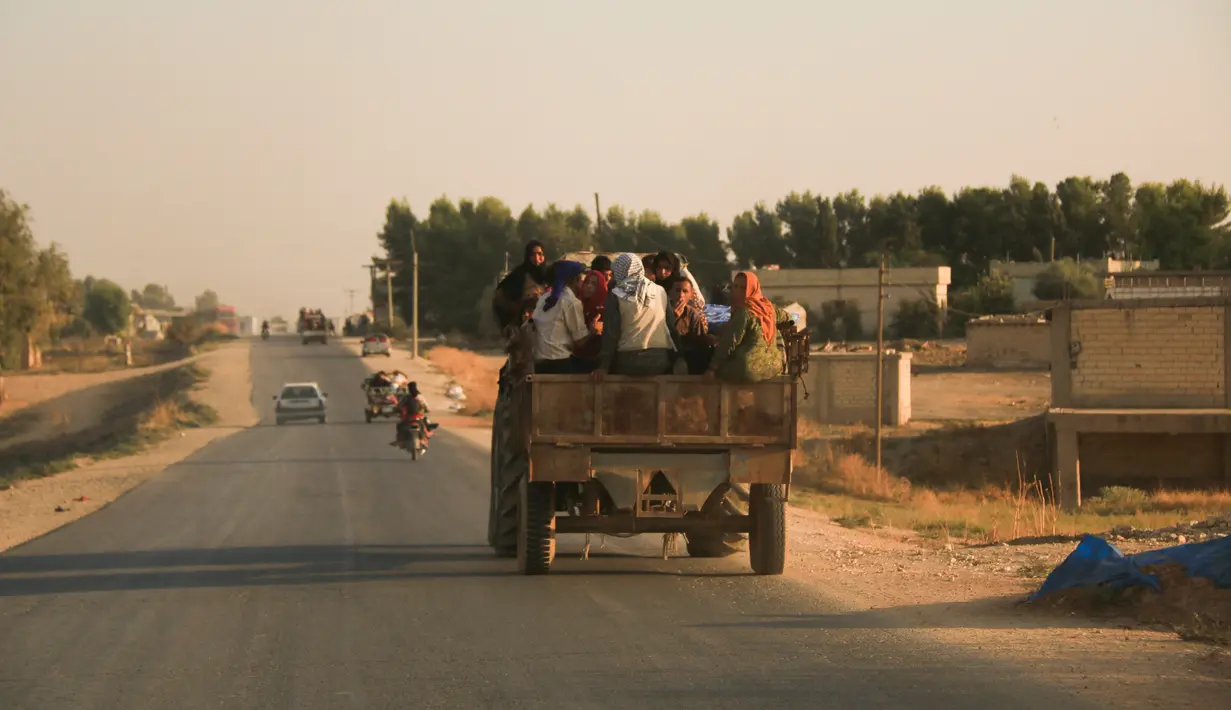 Warga melarikan diri menggunakan mobil saat pasukan Turki memburu milisi Kurdi di Ras al Ayn, Suriah, Rabu (9/10/2019). Dilaporkan bahwa 25 jet tempur Turki berpartisipasi dalam fase awal serangan, dan menjatuhkan bomnya total di 16 target seantero perbatasan. (AP Photo/Baderkhan Ahmad)