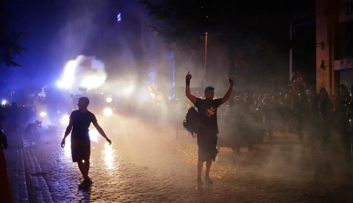 Polisi menggunakan meriam air untuk melawan demonstran yang menentang penyelenggaraan KTT G20 di Hamburg, Kamis (6/7). Polisi antihuru-hara Jerman bentrok dengan pengunjuk rasa jelang pertemuan puncak G20 yang digelar pada 7-8 Juli. (AP/Markus Schreiber)