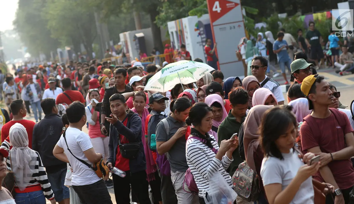 Calon penonton antre untuk mendapatkan tiket final bulu tangkis beregu putra di sekitar tiket boks di kawasan GBK, Jakarta, Rabu (22/8). Laga final bulu tangkis beregu putra mempertemukan Indonesia melawan China. (Liputan6.com/Helmi Fithriansyah)