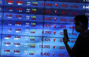 Karyawan berjalan di depan layar Indeks Harga Saham Gabungan (IHSG) di Bursa Efek Indonesia, Jakarta, Jumat (22/1/2021). Indeks acuan bursa nasional tersebut turun 96 poin atau 1,5 persen ke 6.317,864. (Liputan6.com/Johan Tallo)