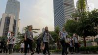 Pekerja berjalan kaki di sepanjang Jalan Jenderal Sudirman, Jakarta, Senin (10/6/2024). (Liputan6.com/Herman Zakharia)