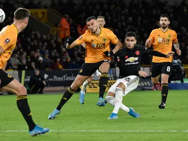 Gelandang Manchester United, Andreas Pereira menendang bola dibayangi pemain Wolverhampton Wanderers pada babak ketiga Piala FA di Molineux, Sabtu (4/1/2020). Wolverhampton dan MU dipaksa untuk melakukan laga ulangan di Old Trafford setelah bermain imbang tanpa gol. (AP/Rui Vieira)