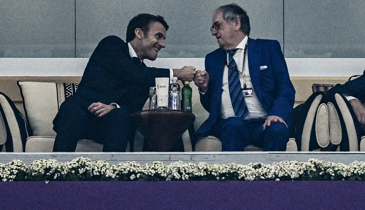 Presiden Prancis Emmanuel Macron (kiri) menyapa presiden Federasi Sepak Bola Prancis, Noël Le Graët, setelah penyerang  Randal Kolo Muani mencetak gol kedua ke gawang Maroko pada pertandingan semifinal Piala Dunia 2022 di Stadion Al Bayt di Al Khor, Qatar, Kamis (15/12/2022). Prancis berhasil melaju ke babak final setelah mengalahkan Maroko 2-0. (AFP/Gabriel Bouys)