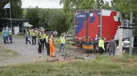 Polisi dan penyelamat berdiri di lokasi di mana sebuah truk menabrak sebuah pertemuan di desa Nieuw-Beijerland, Belanda, Sabtu 27 Agustus 2022. Sebuah truk melaju dari tanggul dan menabrak sebuah komunitas barbekyu di sebuah desa di selatan Rotterdam pada hari Sabtu membunuh dan melukai beberapa orang. (Media TV melalui AP)