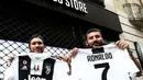 Suporter memperlihatkan jersey Juventus atas nama Cristiano Ronaldo di depan toko resmi klub di Turin, Selasa (10/7). Ronaldo akan diperkenalkan secara resmi ke publik sebagai pemain Juventus pada Senin depan. (AFP PHOTO / Isabella Bonottovv)