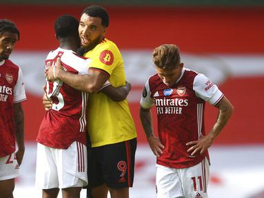 Pemain Arsenal, Ainsley Maitland-Niles, berusaha menenangkan pemain Watford, Troy Deeney, pada laga Premier League di Stadion Emirates, Minggu (26/7/2020). Arsenal menang 3-2 atas Watford. (AP photo/Neil Hall, Pool)
