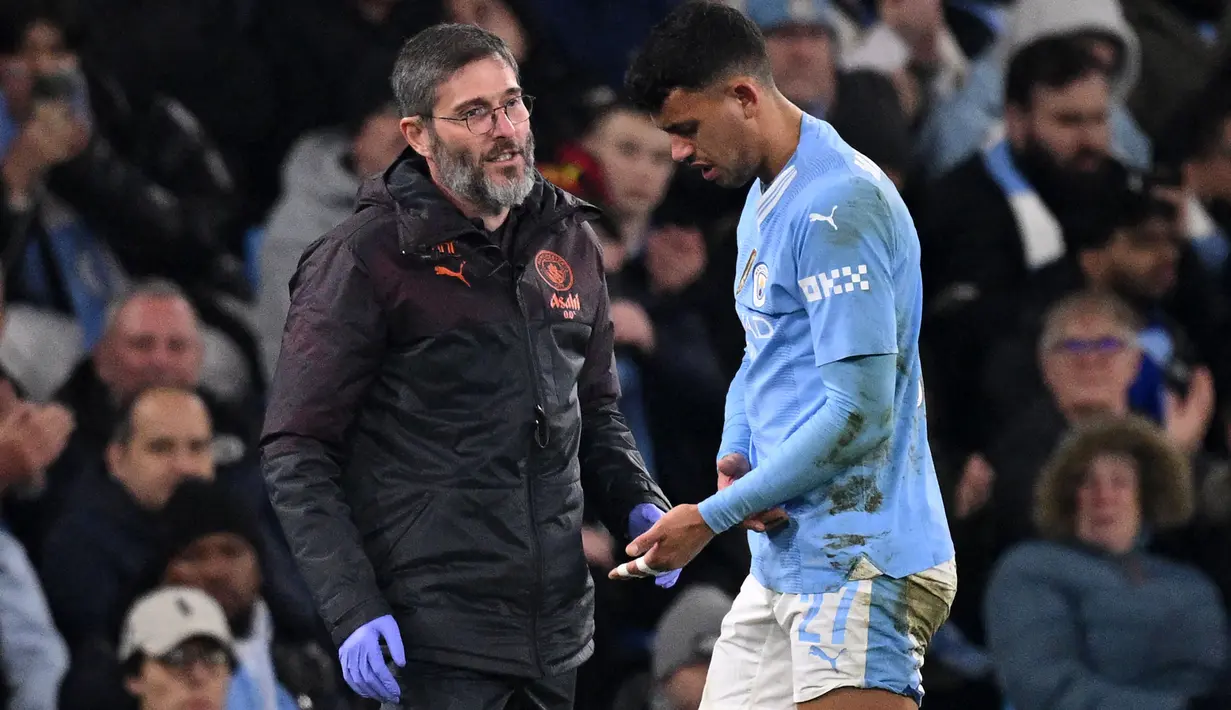 Pemain Manchester City, Matheus Nunes meninggalkan lapangan pertandingan setelah mengalami dislokasi pada jari tengah tangan kirinya ketika laga leg kedua 16 besar Liga Champions 2023/2024 melawan FC Copenhagen di Etihad Stadium, Manchester, Inggris, Kamis (07/03/2024) WIB. (AFP/Oli Scarff)