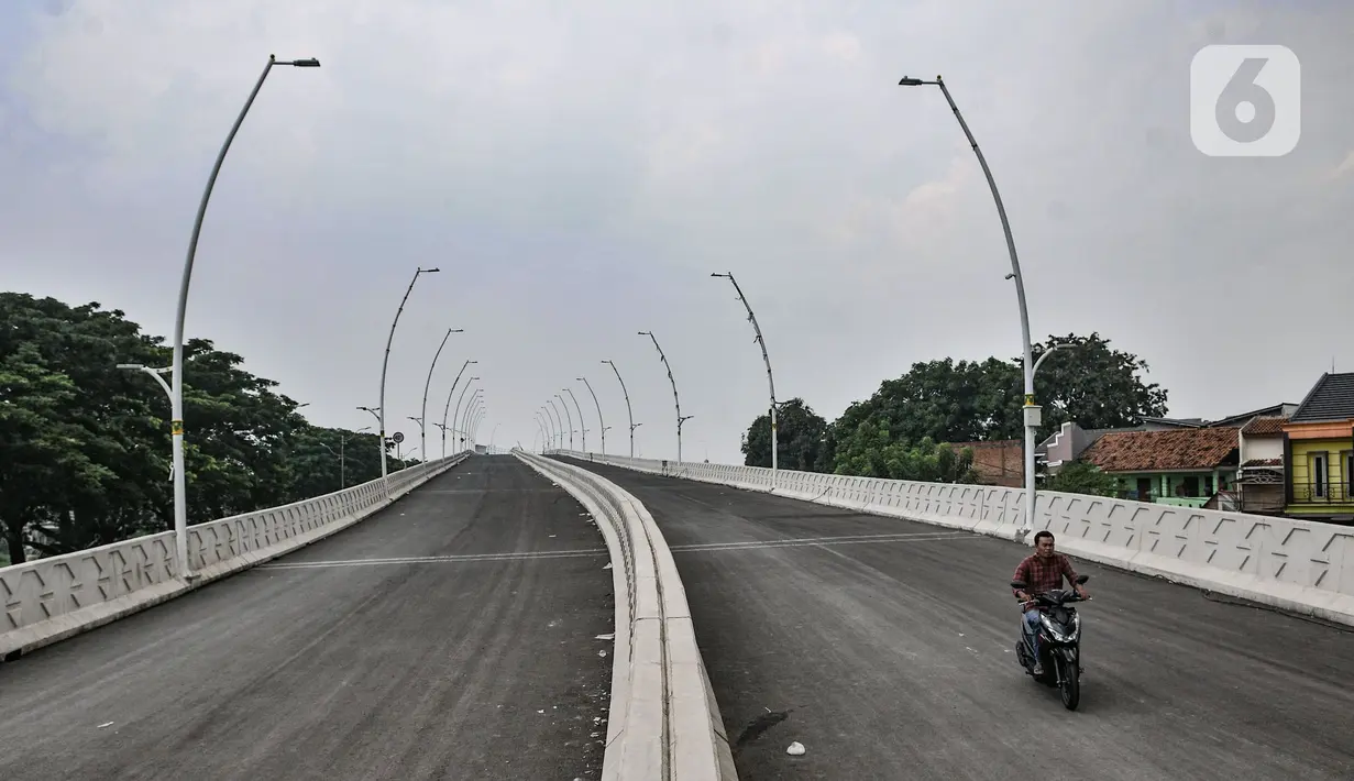 Pengendara sepeda motor saat melintas di jalan layang (Flyover) Cakung, Jakarta Timur, Selasa (16/3/2021). Progres pembangunan flyover yang menghubungkan kawasan Duren Sawit dengan Cakung tersebut saat ini telah mencapai 96,44 persen. (merdeka.com/Iqbal S. Nugroho)