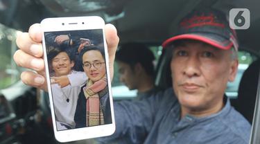 Pihak keluarga menunjukan foto anggota saat menunggu kepulangan WNI yang sudah selesai menjalani observasi di Natuna, di Bandara Halim Perdana Kusuma, Jakarta, Sabtu (15/2/2020). Pemerintah resmi memulangkan 238 WNI ke daerah masing-masing karena telah dinyatakan sehat (Liputan6.com/Herman Zakharia)