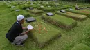Warga saat berziarah saat Idul Fitri 1446 H di makam khusus Covid-19 TPU Srengseng Sawah, Jakarta, Selasa (1/4/2025). (merdeka.com/Arie Basuki)