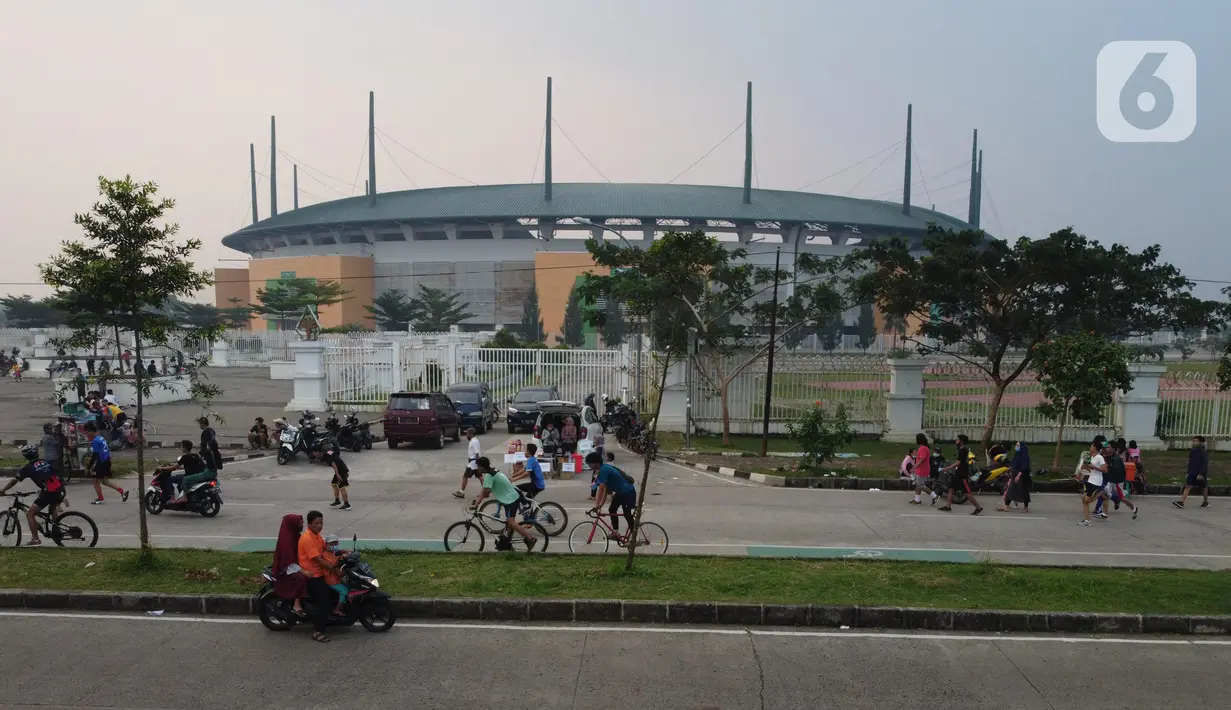 Foto udara memperlihatkan aktivitas warga di jalan lingkar kawasan Stadion Pakansari, Kabupaten Bogor, Jawa Barat, Minggu (28/6/2020). Meski area tersebut belum dibuka kembali, namun warga tetap masuk untuk melakukan beragam aktivitas di kawasan tersebut. (Liputan6.com/Helmi Fithriansyah)