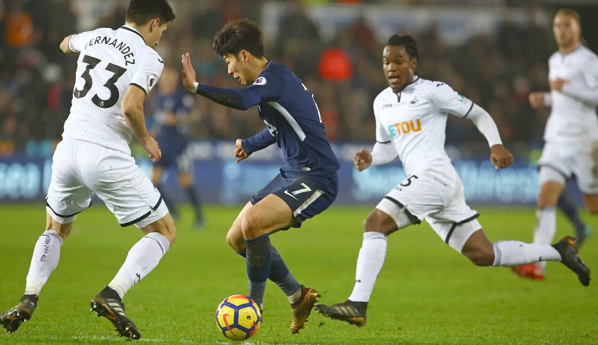 Pemain Tottenham, Son Heung-Min (tengah) berusaha melewati adangan dua pemain Swansea City  pada lanjutan Premier League di The Liberty Stadium, Swansea, (2/1/2018). Tottenham menang 2-0. (AFP/Geoff Caddick)