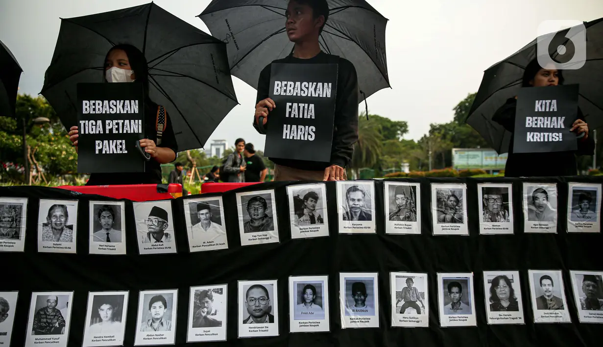 Anggota Jaringan Solidaritas Korban untuk Keadilan (JSKK) membawa poster bertuliskan "Bebaskan Tiga Petani Pakel", "Bebaskan Fatia Haris", dan "Kita Berhak Kritis!" saat melakukan Aksi Kamisan ke-795 di seberang Istana Merdeka, Jakarta, Kamis (16/11/2023). (Liputan6.com/Faizal Fanani)