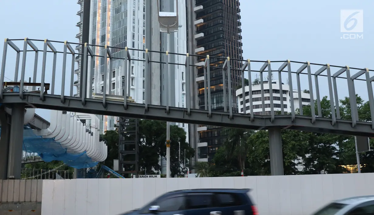 Pengendara melintas di sisi JPO Ratu Plaza di Jalan Jenderal Sudirman, Jakarta, Selasa (11/12). JPO Ratu Plaza merupakan 1 dari 12 JPO di sepanjang jalan Jend Sudirman - MH Thamrin yang masuk dalam proses revitalisasi. (Liputan6.com/Helmi Fithriansyah)