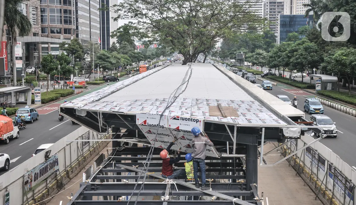 Kendaraan melintas di samping proyek revitalisasi halte TransJakarta Gelora Bung Karno (GBK), Jakarta Pusat, Senin (25/7/2022). PT TransJakarta terus mengebut proyek konstruksi revitalisasi sembilan halte yang akan berlangsung sekitar enam bulan dan akan difungsikan kembali secara bertahap sampai dengan dirampungkan secara keseluruhan pada Desember 2022. (merdeka.com/Iqbal S Nugroho)