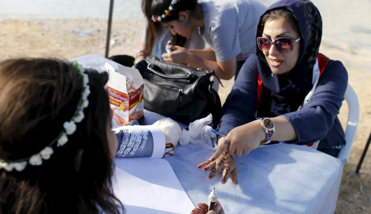 Seorang pengunjung dilukis tangannya dengan hiasan inai/pacar tradisional selama Hari Perdamaian Internasional di Baghdad,Irak (21/9/2015). Perayaan diisi dengan kreativitas seni karya para pemuda dan pemudi Irak. (REUTERS/Thaier al-Sudani)