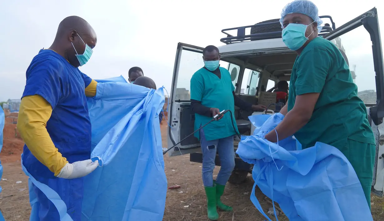 Seorang petugas kesehatan menyemprotkan disinfektan ke tubuh rekannya setelah mengikuti prosesi pemakaman seorang anak berusia 3 tahun yang meninggal akibat Ebola, di Bunia, Provinsi Ituri, Kongo bagian timur, Selasa, 18 Agustus 2026. (Foto AP/Dieudonne Dirole)