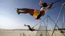 Pengunjung bermain ayunan dalam festival musik dan seni Burning Man 2015 di Gurun Black Rock, Nevada, (1/9/2015). Festival ini mengangkat tema "Carnival of Mirrors." (REUTERS/Jim Urquharther)