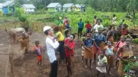 Presiden Jokowi menggendong seorang anak saat berkunjung ke Kabupaten Asmat, Papua (Liputan6.com/ Hanz Jimenez Salim)