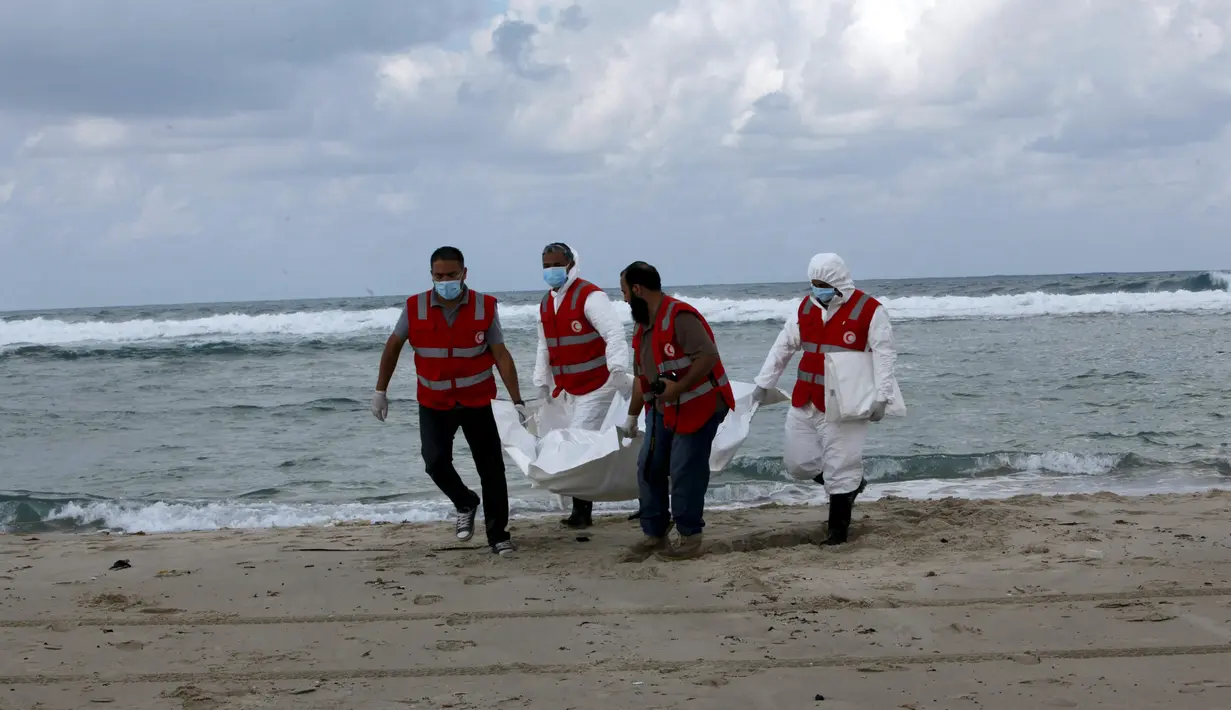 Kelompok Bulan Sabit Merah Libya membawa kantong mayat berisi jenazah, diduga imigran yang tewas tenggelam di pantai Khoms, sebelah timur Tripoli, Minggu (25/10). Sedikitnya 40 jasad telah ditemukan di pantai Libya. (REUTERS/Ismail Zitouny)