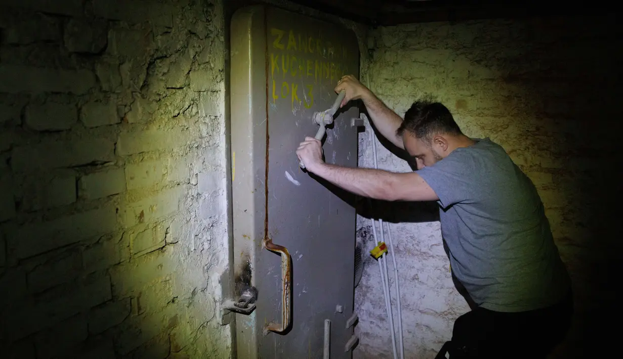 Warga setempat, Jacek (37), menutup pintu ke tempat perlindungan di ruang bawah tanah sebuah bangunan perumahan di Warsawa, Polandia, 19 Oktober 2022. Pertempuran di sekitar pembangkit listrik tenaga nuklir Ukraina dan ancaman Rusia untuk menggunakan senjata nuklir telah membangkitkan kembali ketakutan Eropa akan nuklir. (AP Photo/Michal Dyjuk)