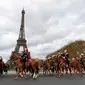 Pasukan berkuda Prancis membentuk formasi saat melintas di depan Menara Eiffel dalam parade kuda ke-20 di Paris, Prancis (19/11). Acara ini menjadi ajang untuk berkumpul bagi mereka pecinta kuda. (AFP Photo/Thomas Samson)