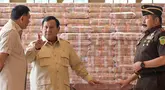 Presiden Prabowo Subianto (tengah) berbicara dengan Jaksa Agung Sanitiar Burhanuddin (kanan) dan Menteri Pertahanan Indonesia Sjafrie Sjamsoeddin di samping tumpukan uang kertas rupiah Indonesia senilai 800 juta USD di gedung Kejaksaan Agung Republik Indonesia, Jakarta, Senin 20 Oktober 2025. (BAY ISMOYO/AFP)