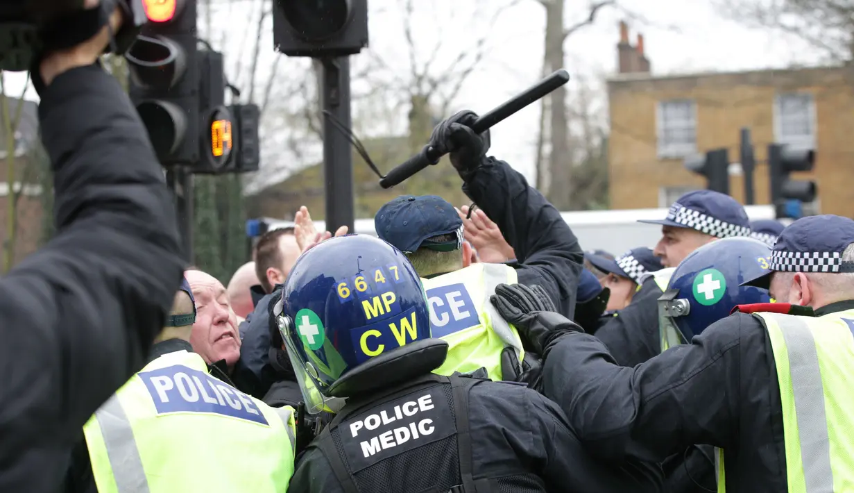 Petugas kepolisian saat terlibat bentrok dengan suporter Millwall sebelum pertandingan perempat final Piala FA antara Tottenham Hotspur melawan Millwall di White Hart Lane, London, (12/3). (Yui Mok//PA via AP)