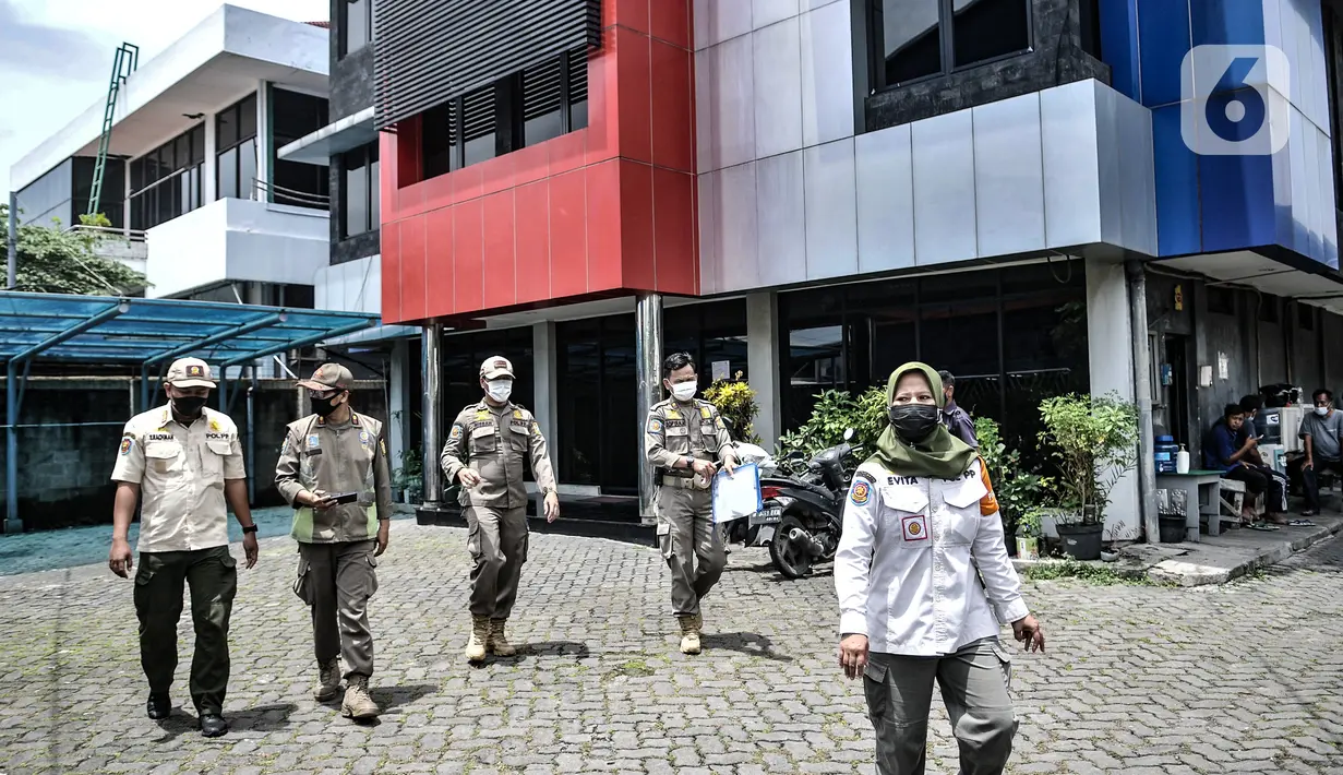 Petugas Satpol PP Kecamatan Tanjung Priok seusai melakukan sidak di salah satu perkantoran kawasan Sunter, Jakarta, Rabu (10/2/2021). Sidak tersebut merupakan bagian dari penerapan Pemberlakuan Pembatasan Kegiatan Masyarakat (PPKM) skala mikro. (merdeka.com/Iqbal s Nugroho)