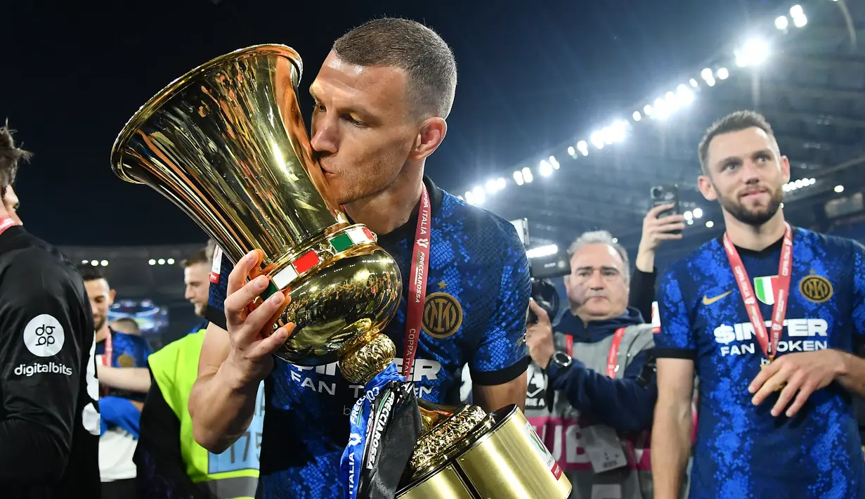 <p>Pemain depan Inter Milan Edin Dzeko memegang trofi Coppa Italia dan merayakannya kemenangan 4-2 atas Juventus pada pertandingan final di Stadion Olimpico, Roma, Kamis (12/5/2022) dini hari WIB. Bagi Inter Milan, ini gelar juara Coppa Italia 2021/2022 kedelapan setelah sebelumnya sukses menjadi kampiun turnamen ini pada 1939, 1978, 1982, 2005, 2006, 2010, dan 2011. (Isabella BONOTTO / AFP)</p>