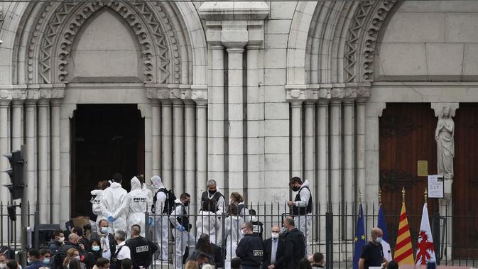 Polisi Prancis dan petugas forensik bekerja menangani kasus penikaman di gereja Notre Dame di Nice, Prancis, pada Kamis (29/10/2020). (Foto credit: AP/Daniel Cole)