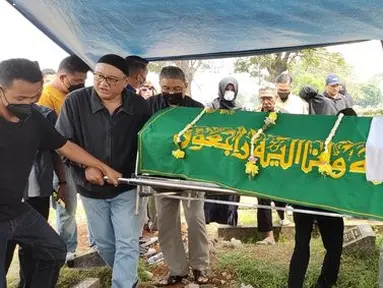 Tiba di pemakaman, jenazah Yulla Heri Burhania langsung dibawa ke pinggir liang lahat. Seorang ustaz kemudian langsung mengarahkan prosesi pemakaman. Dia meminta tiga orang keluarga untuk turun ke liang lahat, salah satunya adalah ayah Ressa Herlambang, Herman.(Muhammad Akrom Sukarya/Kapanlagi.com)