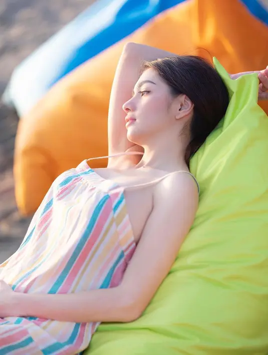 <p>Salah satu unggahan Angel Karamoy kala tengah tiduran beralaskan bantal di pesisir sambil menikmati suasana keindahan pantai. (FOTO: instagram.com/realangelkaramoy)</p>