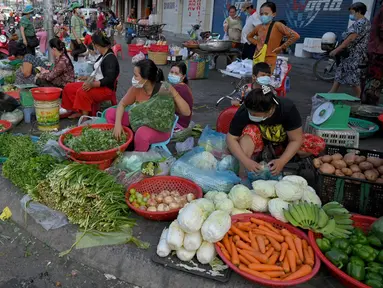 Pedagang menyiapkan sayuran untuk dijual di sepanjang jalan karena pasar tetap tutup di tengah pembatasan lockdown yang diberlakukan untuk mencoba menghentikan lonjakan kasus virus corona COVID-19 di Phnom Penh, Kamboja, Selasa (11/5/2021). (TANG CHHIN Sothy/AFP)