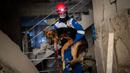 Anggota kelompok hak asasi hewan Turki, HAYTAP, Mehmet Gurkan menyelamatkan seekor anjing yang terperangkap selama tujuh hari di dalam rumah yang terkena dampak gempa di Antakya, Turki, 12 Februari 2023. (AP Photo/Bernat Armangue)