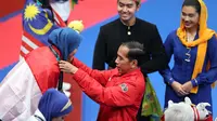 Presiden RI, Joko Widodo, mengalungkan medali kepada atlet taekwondo, Defia Rosmaniar, pada Asian Games 2018 di JCC, Jakarta, Minggu (19/8/2018). Defia menang dengan skor 8.690-8.470 atas wakil Iran Salahshouri Marjan. (Bola.com/Peksi Cahyo)