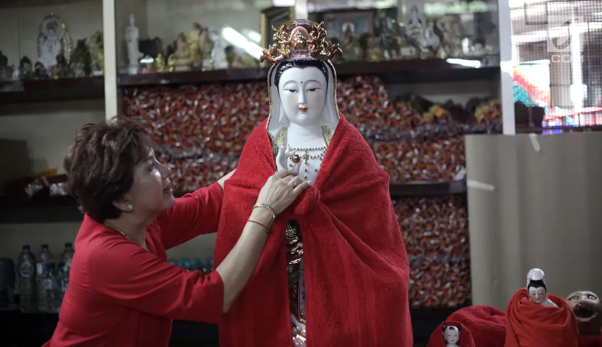 Seorang warga mengeringkan patung dewa-dewi di Vihara Amurva Bhumi, Jakarta, Kamis (8/2). Tradisi membersihkan patung ini bertujuan untuk memberi penghormatan kepada seluruh dewa-dewi. (Liputan6.com/Arya Manggala)