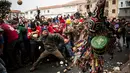 Orang-orang melempari seorang pria berkostum ala setan dengan sayuran lobak selama Festival Jarramplas di kota Piornal, Spanyol, Sabtu (19/1). Sosok "setan" itu disebut dengan Jarramplas yang dikenakan salah satu pemuda desa terpilih. (AP/Javier Fergo)