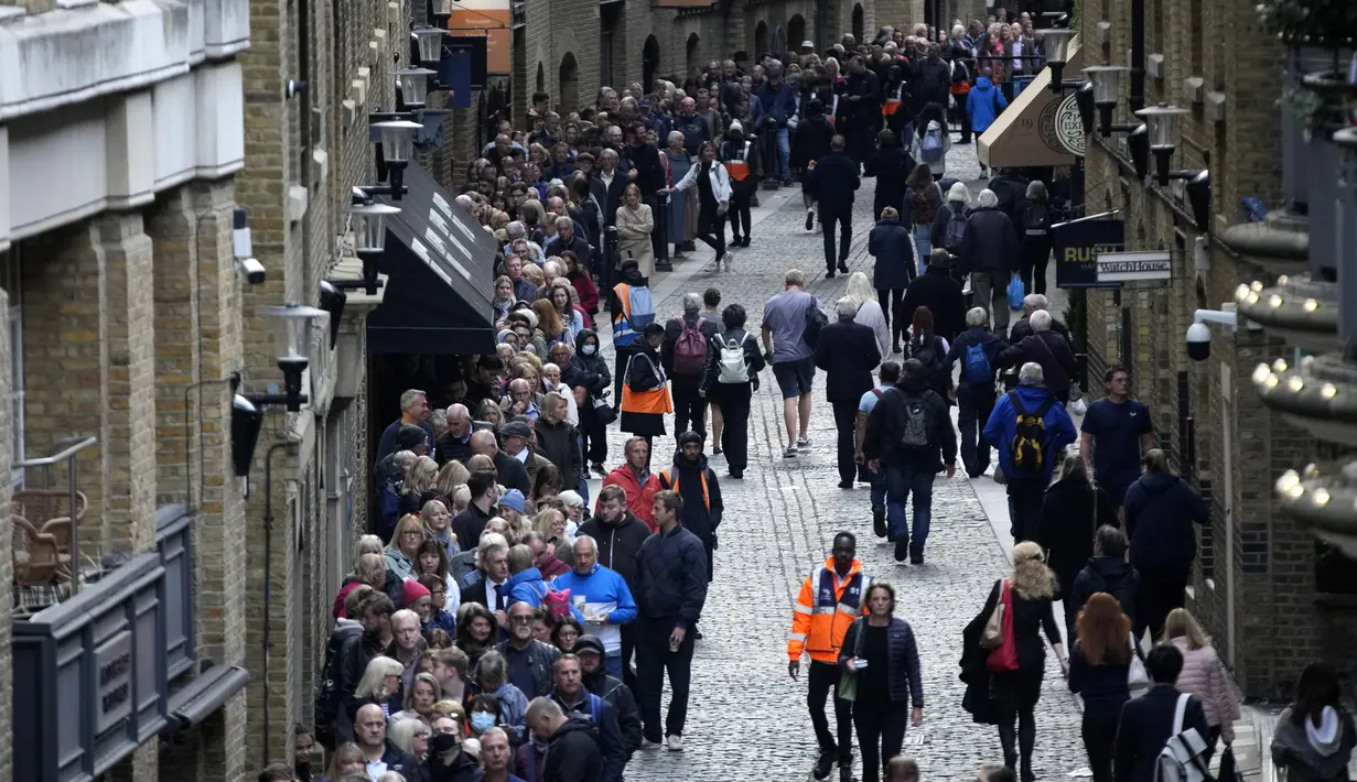 Orang-orang antre dekat Tower Bridge untuk memberi penghormatan kepada mendiang Ratu Elizabeth II yang terbaring di Westminster Hall, London pada 16 September 2022. Pengunjung yang berkerumun ke pusat kota London untuk momen bersejarah memberikan dorongan bagi bisnis pada saat ekonomi Inggris menghadapi krisis biaya hidup yang dipicu inflasi tertinggi dalam empat dekade dan prediksi dari resesi yang mengancam. (AP Photo/Christophe Ena)