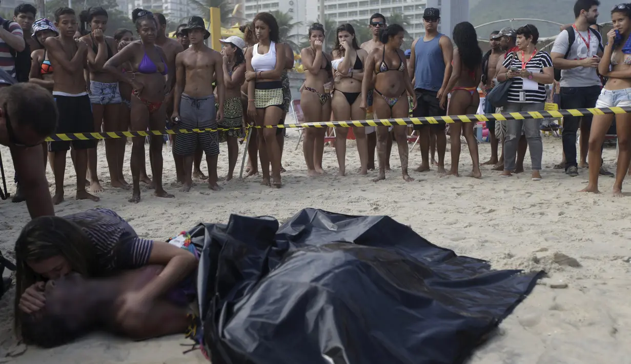 Wanita bernama  Eliane mencium suaminya yang tewas Eduardo Marinho Albuquerque di pantai, Rio de Janeiro , Brasil , 21 April 2016. Menurut kabar pria ini tewas setelah terjatuh dari bangunan yang runtuh akibat diterjang ombak. (REUTERS / Ricardo Moraes) 