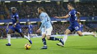 Gelandang Manchester City, David Silva menggiring bola dari kawalan pemain Chelsea, Cesar Azpilicueta dan Antonio Rudiger selama pertandingan Liga Premier Inggris di Stamford Bridge di London (8/12). Chelsea menang 2-0 atas City. (AP Photo/Tim Ireland)