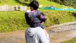 Shaheer Sheikh mengendong putrinya di atas pundaknya sambil menyusuri pinggir kali yang airnya mengalir. (Foto: Instagram/@shaheernsheikh)