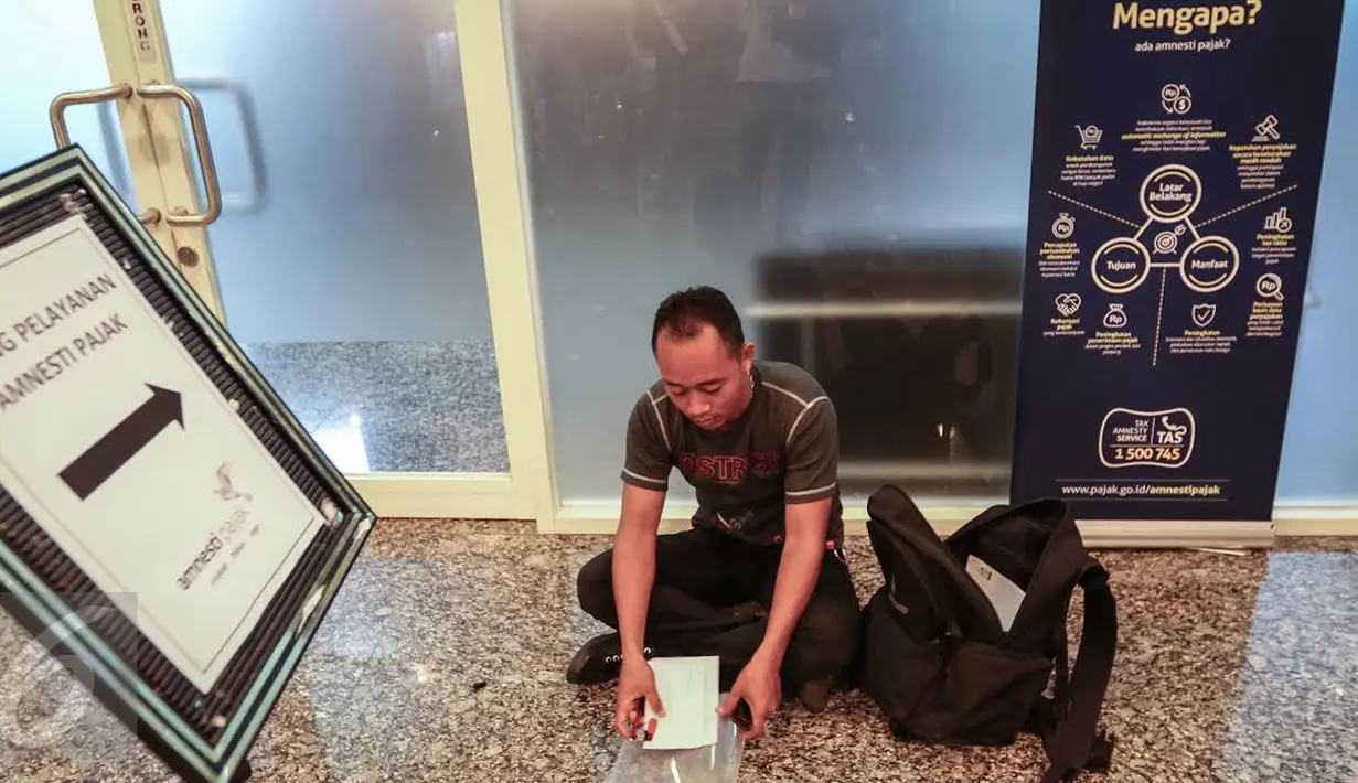 Seorang wajib pajak menyiapkan dokumen pajak di kantor pusat Direktorat Jenderal Pajak (Ditjen Pajak), Gatot Subroto, Jakarta, Minggu (25/9). Peserta program tax amnesty semakin meningkat mendekati hari akhir periode pertama. (Liputan6.com/Fery Pradolo)