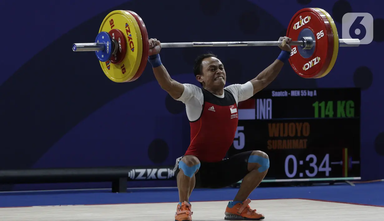 Lifter putra Indonesia, Suratman melakukan angkatan saat SEA Games 2019 cabang angkat besi nomor 55 kg di Stadion Rizal Memorial, Manila, Minggu (1/12/2019). Dirinya meraih perak dengan total angkatan 250 kg. (Bola.com/M Iqbal Ichsan)