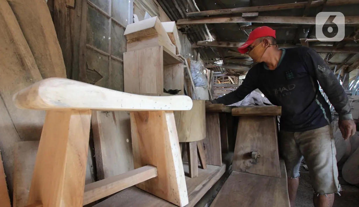 Perajin menyelesaikan pembuatan kursi dari kayu bekas di Pinang, Kota Tangerang, Banten, Minggu (28/3/2021). Furnitur berbahan dasar kayu bekas tersebut dijual dari harga Rp50.000 hingga lima juta rupiah dan dipasarkan hingga ke Sumatera dan Kalimantan. (Liputan6.com/Angga Yuniar)