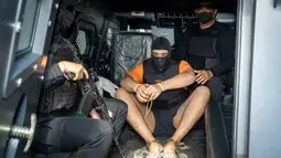 Pelimpahan kasus ini terkait pembunuhan berencana terhadap dua orang warga negara Australia yaitu Zivan Radmanovic dan korban luka Sanar Ghanim di Bali pada 14 Juni 2025 lalu. Tampak dalam foto, tersangka Coskun Mevlut (tengah) saat dibawa kembali ke rumah tahanan setelah menjalani pemeriksaan oleh pihak kejaksaan di Badung, Bali, pada 15 Oktober 2025. (Dicky Bisinglasi/AFP)