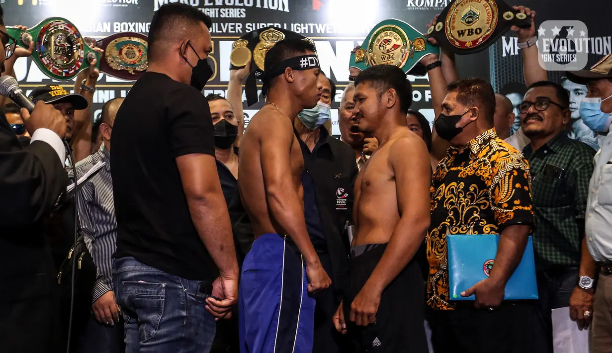 Petinju Indonesia Daud Yordan (kiri) dan lawannya petinju Thailand Panya Uthok saling bertatap mata seusai timbang badan di Balai Sarbini, Jakarta, Kamis (30/6/2022). Face-off antara Daud Yordan dan Panya Uthok berlangsung damai. Kedua petarung saling berpelukan di atas panggung. (Liputan6.com/Johan Tallo)