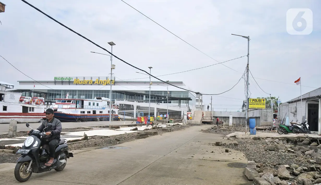 Warga melintasi bekas lokasi warung makan pasca direlokasi di Pelabuhan Kali Adem, Muara Angke, Jakarta Utara, Senin (13/6/2022). Relokasi pedagang sebagai upaya menata kawasan pelabuhan serta menghindari banjir ROB yang kerap terjadi. (merdeka.com/Iqbal S Nugroho)