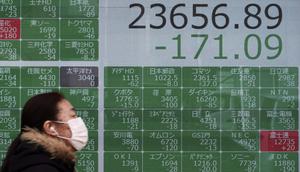 Seorang wanita berjalan melewati layar monitor yang menunjukkan indeks bursa saham Nikkei 225 Jepang dan lainnya di sebuah perusahaan sekuritas di Tokyo, Senin (10/2/2020). Pasar saham Asia turun pada Senin setelah China melaporkan kenaikan dalam kasus wabah virus corona. (AP Photo/Eugene Hoshiko)